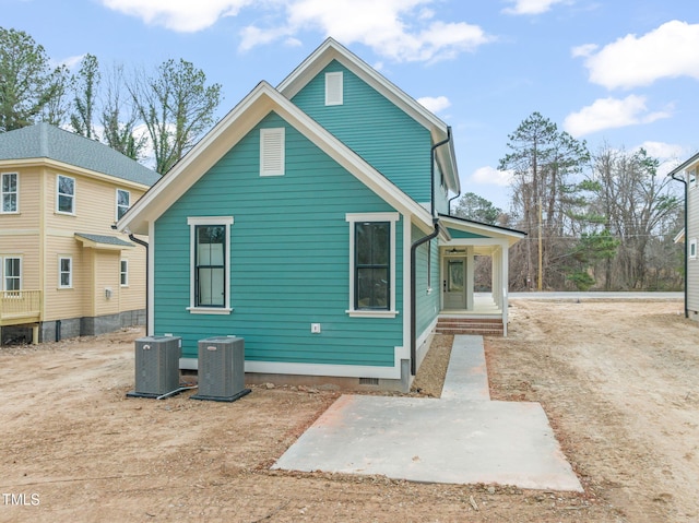 rear view of house featuring central air condition unit and crawl space