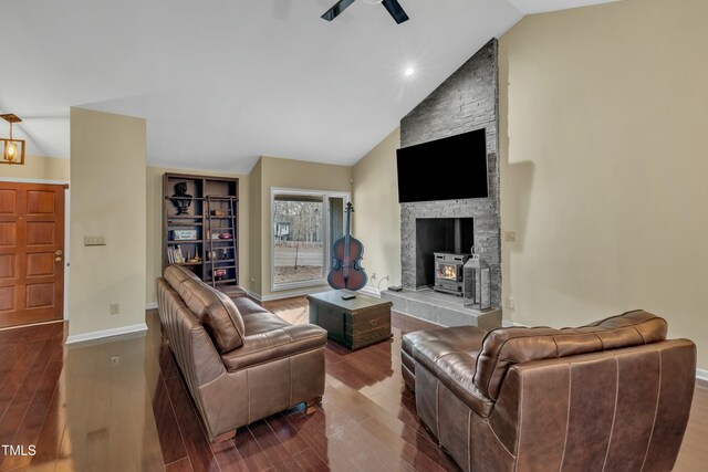 living room with ceiling fan, lofted ceiling, a wood stove, and hardwood / wood-style floors