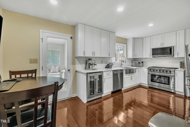 kitchen featuring appliances with stainless steel finishes, wine cooler, and white cabinetry