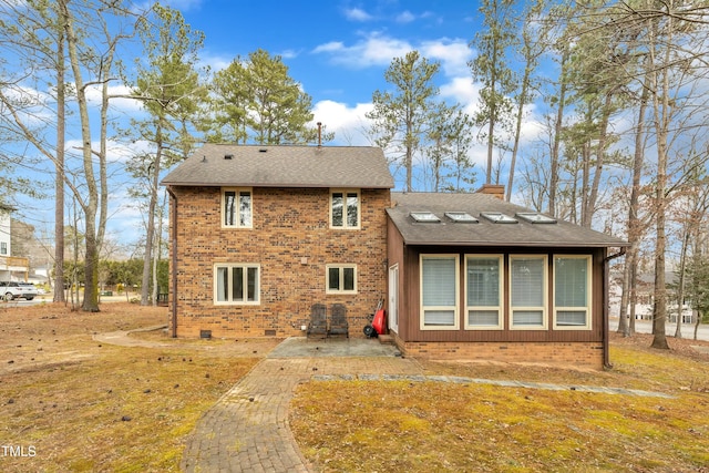 back of property with a yard and a patio