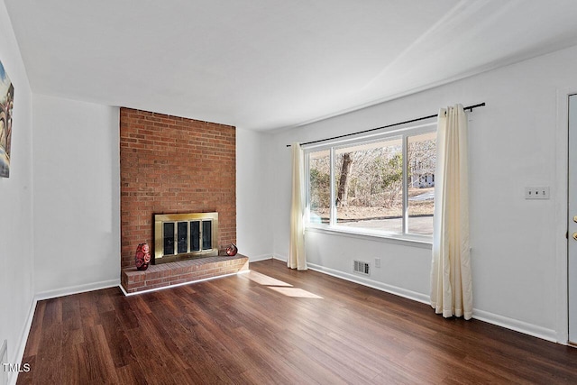 unfurnished living room featuring a fireplace and dark hardwood / wood-style floors