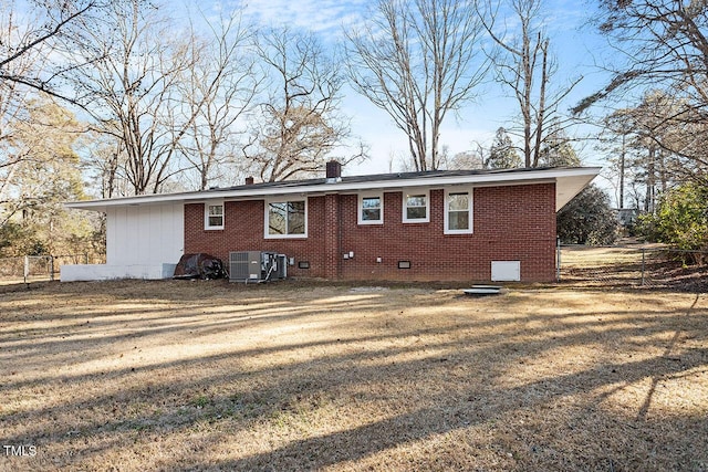 back of house featuring central AC and a yard