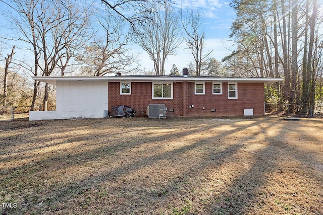 rear view of house with a lawn and central AC