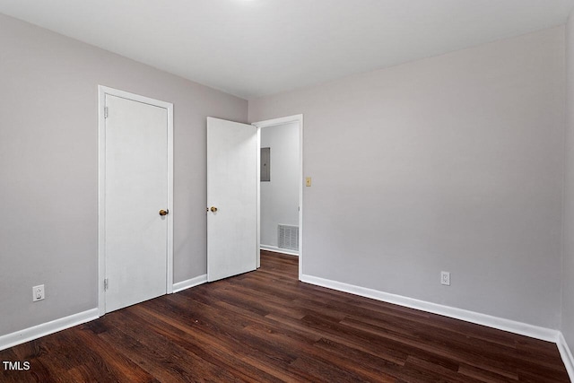 unfurnished bedroom with dark hardwood / wood-style floors and electric panel