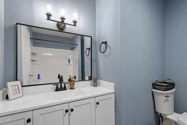 bathroom featuring toilet, vanity, and a shower