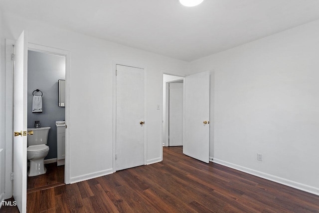 bedroom with dark wood-type flooring and ensuite bathroom