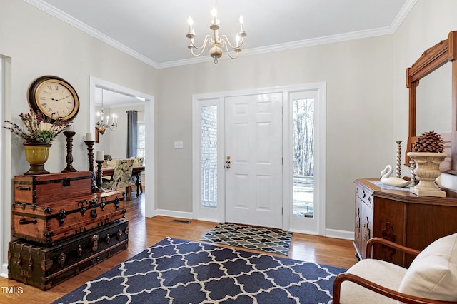 entrance foyer with a healthy amount of sunlight, a chandelier, and hardwood / wood-style flooring