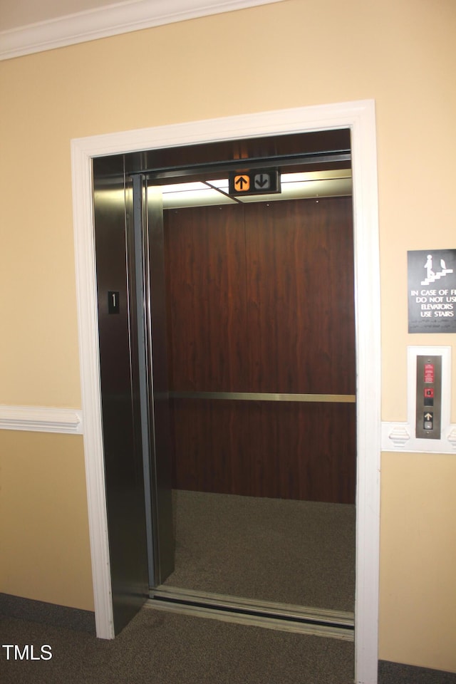 interior details with crown molding and elevator