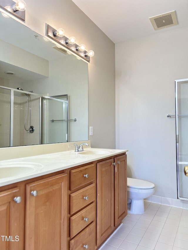 bathroom featuring toilet, tile patterned flooring, a shower with shower door, and vanity