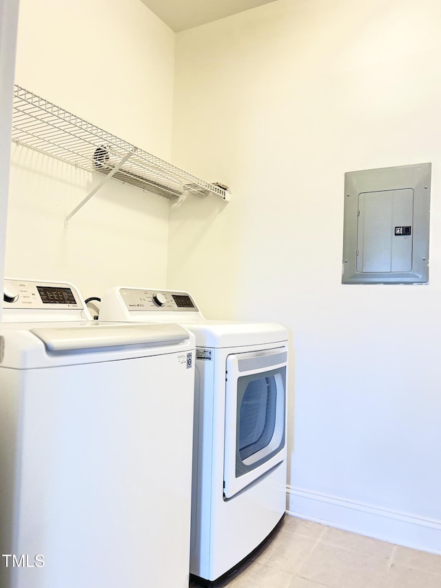 laundry room with light tile patterned flooring, electric panel, and washer and clothes dryer