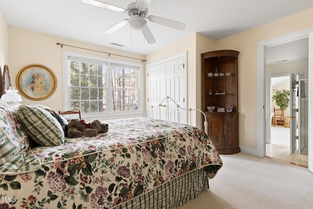 bedroom with ceiling fan, light colored carpet, and a closet