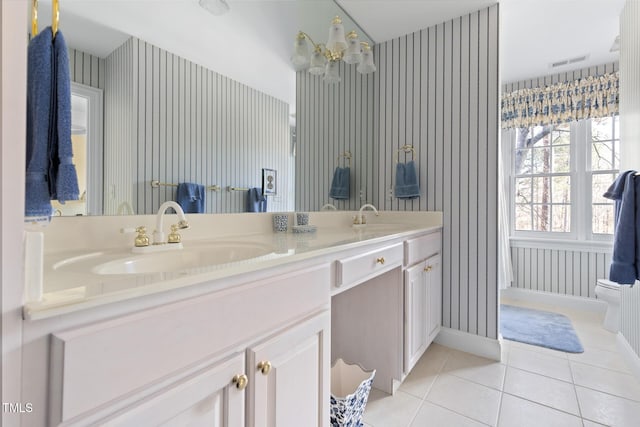 bathroom featuring toilet, tile patterned flooring, an inviting chandelier, and vanity