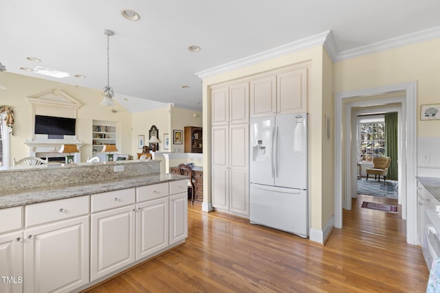 kitchen with light stone counters, decorative light fixtures, light wood-type flooring, white fridge with ice dispenser, and ornamental molding