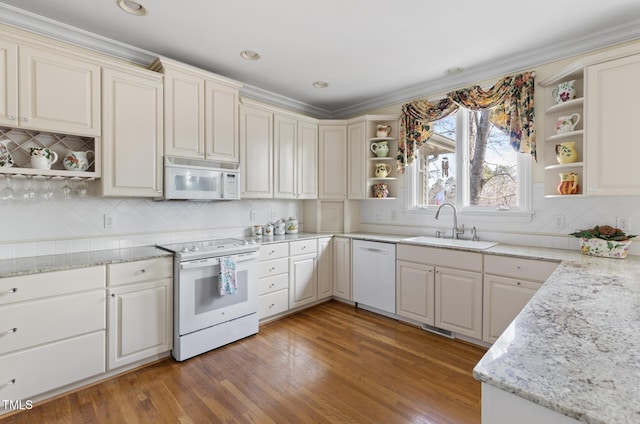 kitchen featuring sink, white appliances, wood-type flooring, backsplash, and light stone countertops