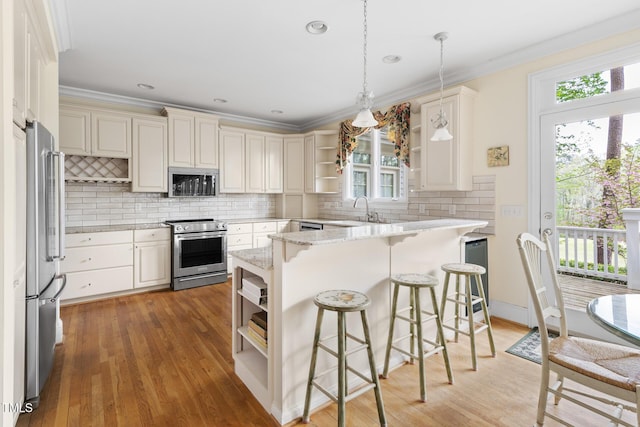 kitchen featuring a kitchen breakfast bar, open shelves, stainless steel appliances, ornamental molding, and a sink