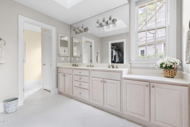 full bathroom featuring a closet, double vanity, a sink, and tile patterned flooring