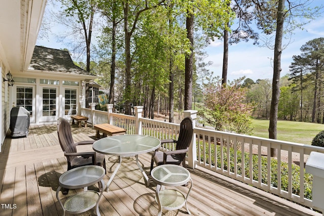 wooden terrace with outdoor dining area and area for grilling