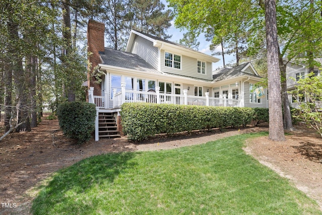 back of house with a lawn, stairway, a deck, and a chimney