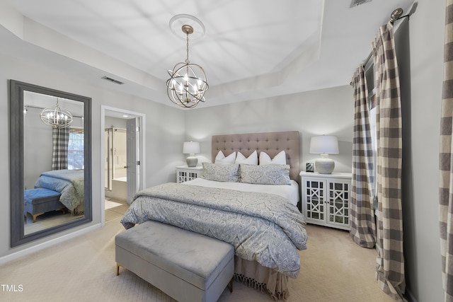 carpeted bedroom featuring ensuite bathroom, a tray ceiling, and a chandelier