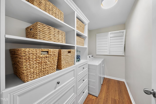 laundry room featuring separate washer and dryer and light hardwood / wood-style flooring