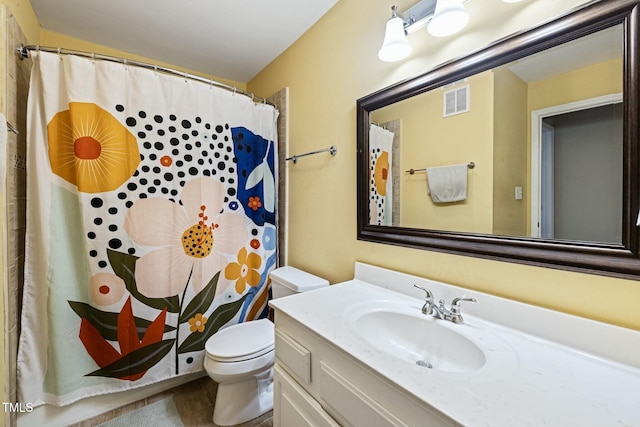 bathroom with toilet, vanity, and walk in shower