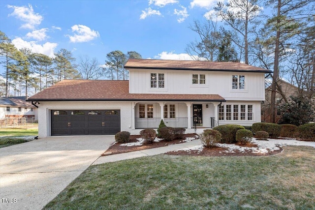 front facade with a garage, a front yard, and covered porch