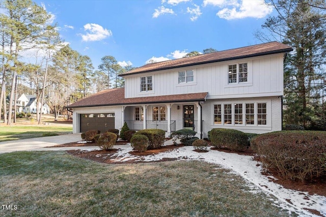 view of front of home with a garage, a front lawn, and a porch