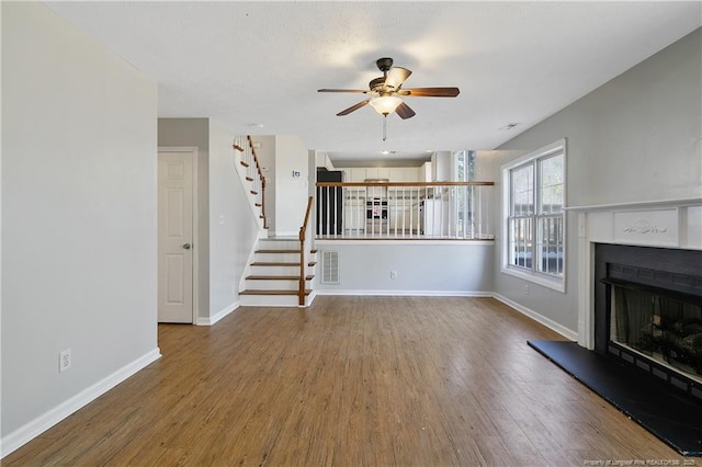 unfurnished living room with ceiling fan and wood-type flooring