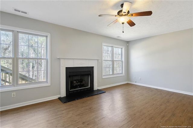 unfurnished living room featuring ceiling fan and dark hardwood / wood-style flooring