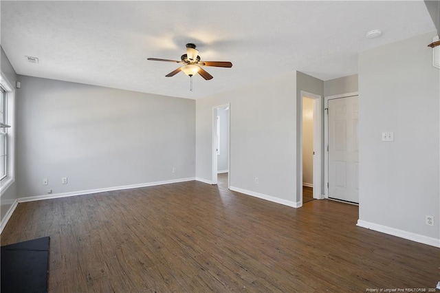 empty room with ceiling fan and dark hardwood / wood-style flooring