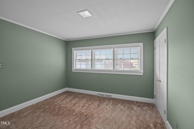 carpeted empty room with a textured ceiling and ornamental molding