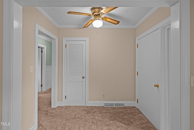 unfurnished bedroom featuring ceiling fan, crown molding, and light colored carpet