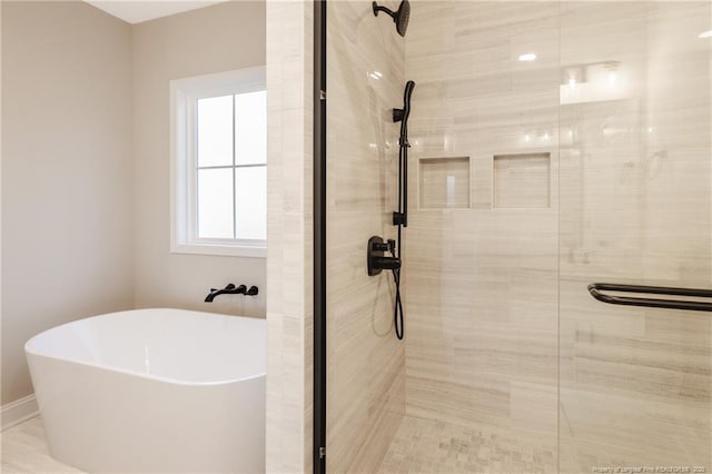 bathroom featuring independent shower and bath