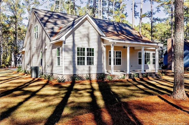 view of front of house featuring a front yard, ceiling fan, central AC, and a porch