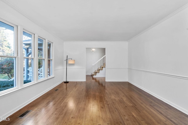 unfurnished room featuring crown molding, dark hardwood / wood-style floors, and an inviting chandelier