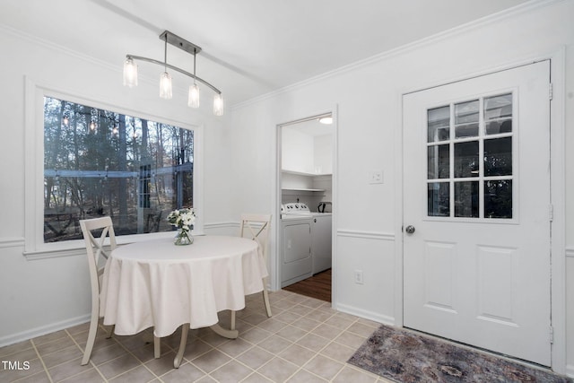 tiled dining area featuring crown molding and washing machine and dryer