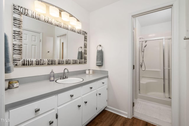 bathroom featuring hardwood / wood-style flooring, vanity, and a shower with shower door