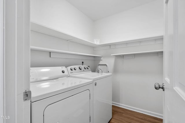 laundry room with dark hardwood / wood-style floors and separate washer and dryer