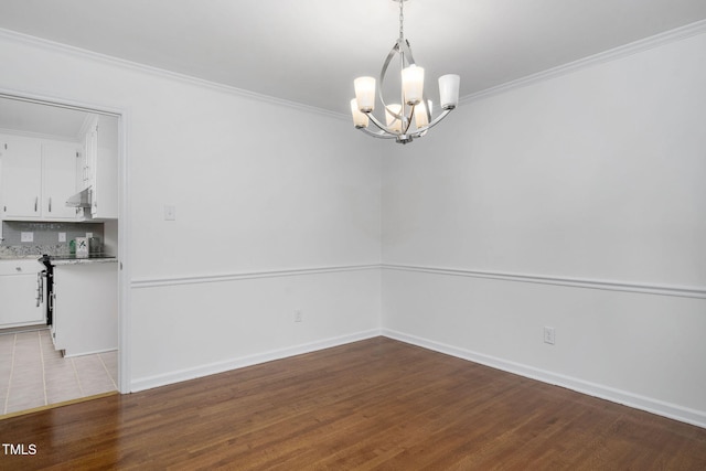 unfurnished dining area with an inviting chandelier, ornamental molding, and light wood-type flooring