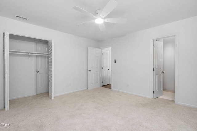 unfurnished bedroom featuring light carpet, a closet, and ceiling fan