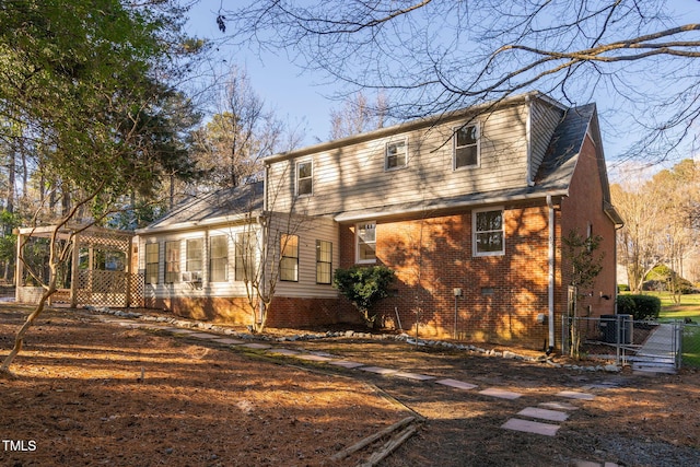 rear view of property featuring a sunroom and central air condition unit