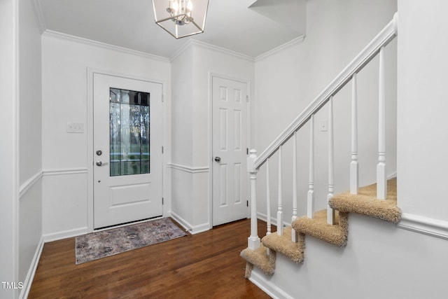 entryway with ornamental molding, a chandelier, and dark hardwood / wood-style flooring