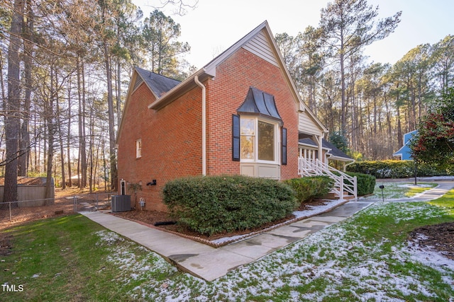 view of side of home featuring a yard and central AC unit