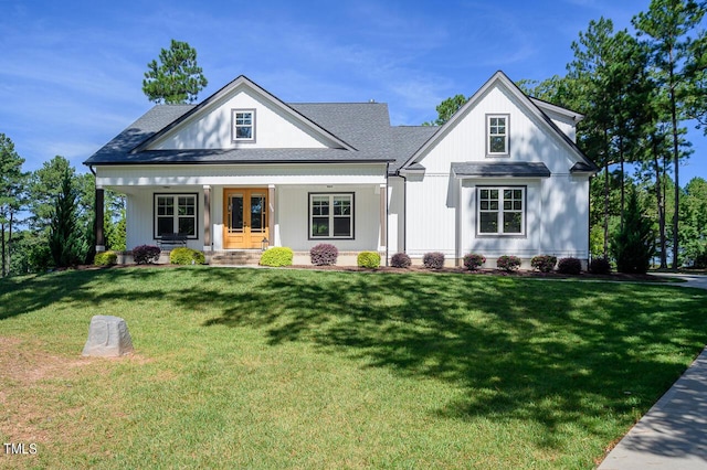 modern farmhouse with french doors, covered porch, and a front lawn