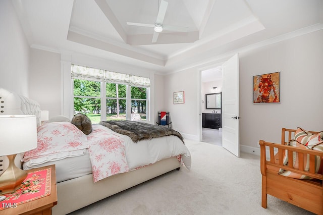 bedroom featuring ensuite bath, ceiling fan, a tray ceiling, ornamental molding, and light carpet