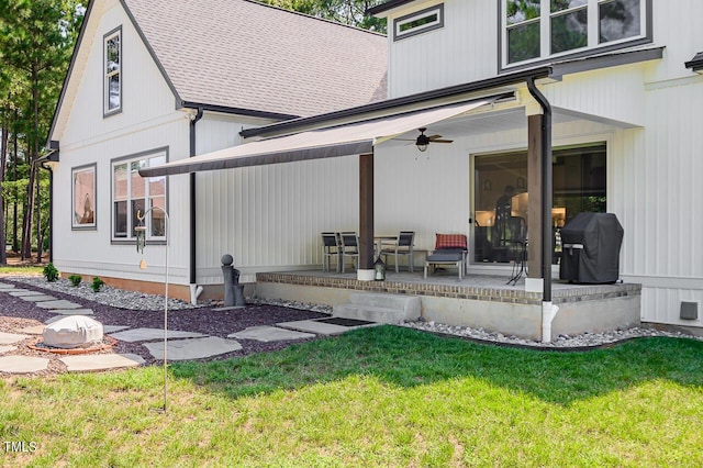 rear view of house with ceiling fan, a yard, and a patio