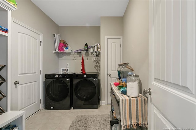 clothes washing area with separate washer and dryer and light tile patterned floors