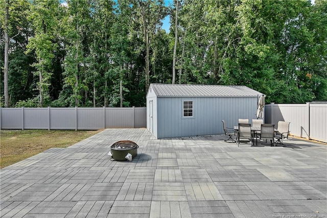 view of patio / terrace featuring a fire pit and an outdoor structure