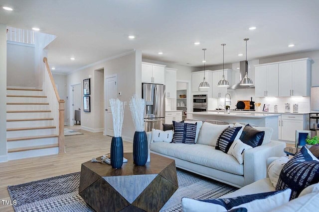 living room featuring light wood-type flooring and crown molding