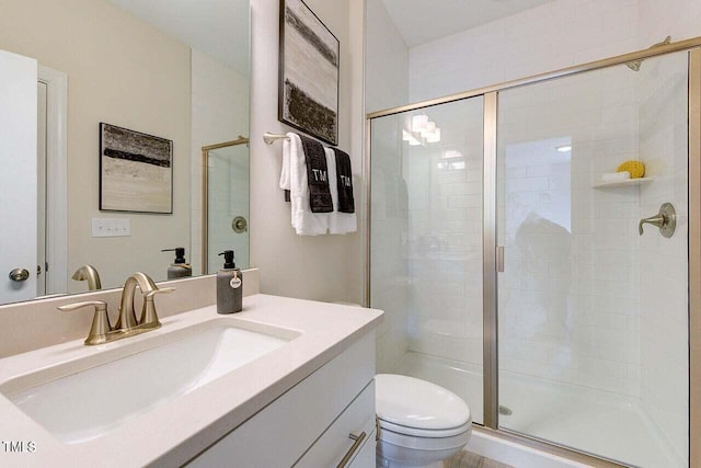 bathroom featuring an enclosed shower, vanity, and toilet